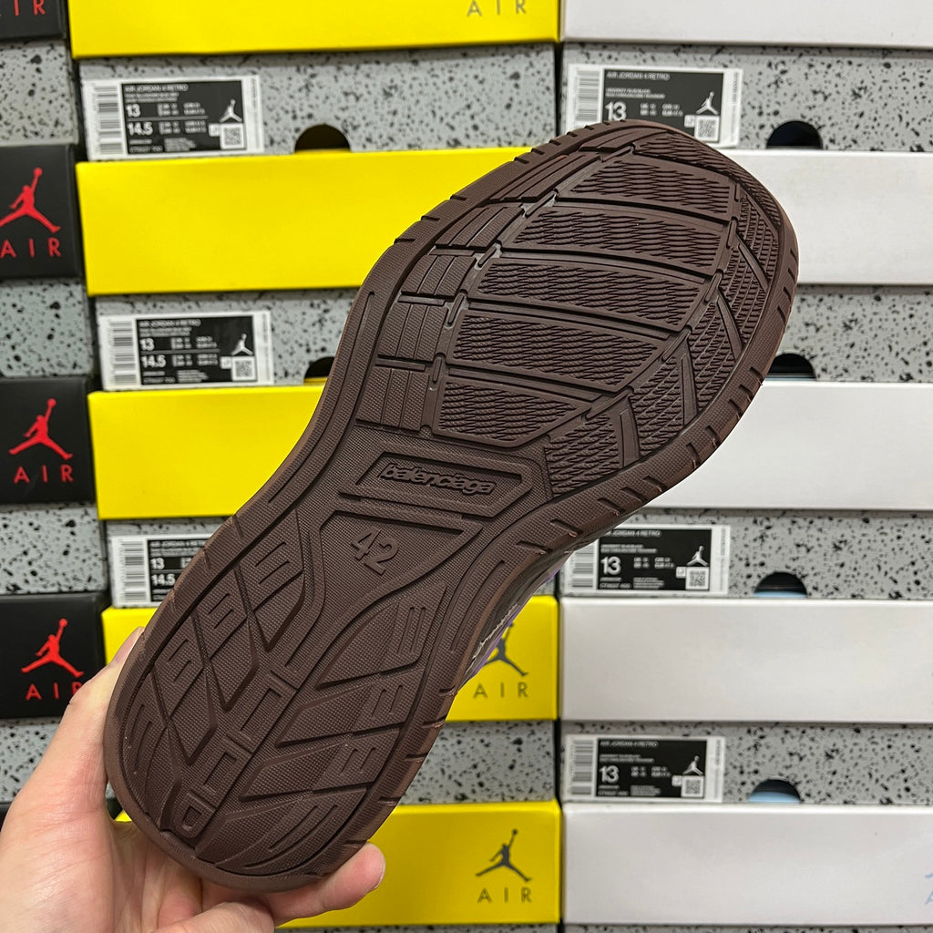 Brown sneaker outsole with textured tread pattern and 42 mark.