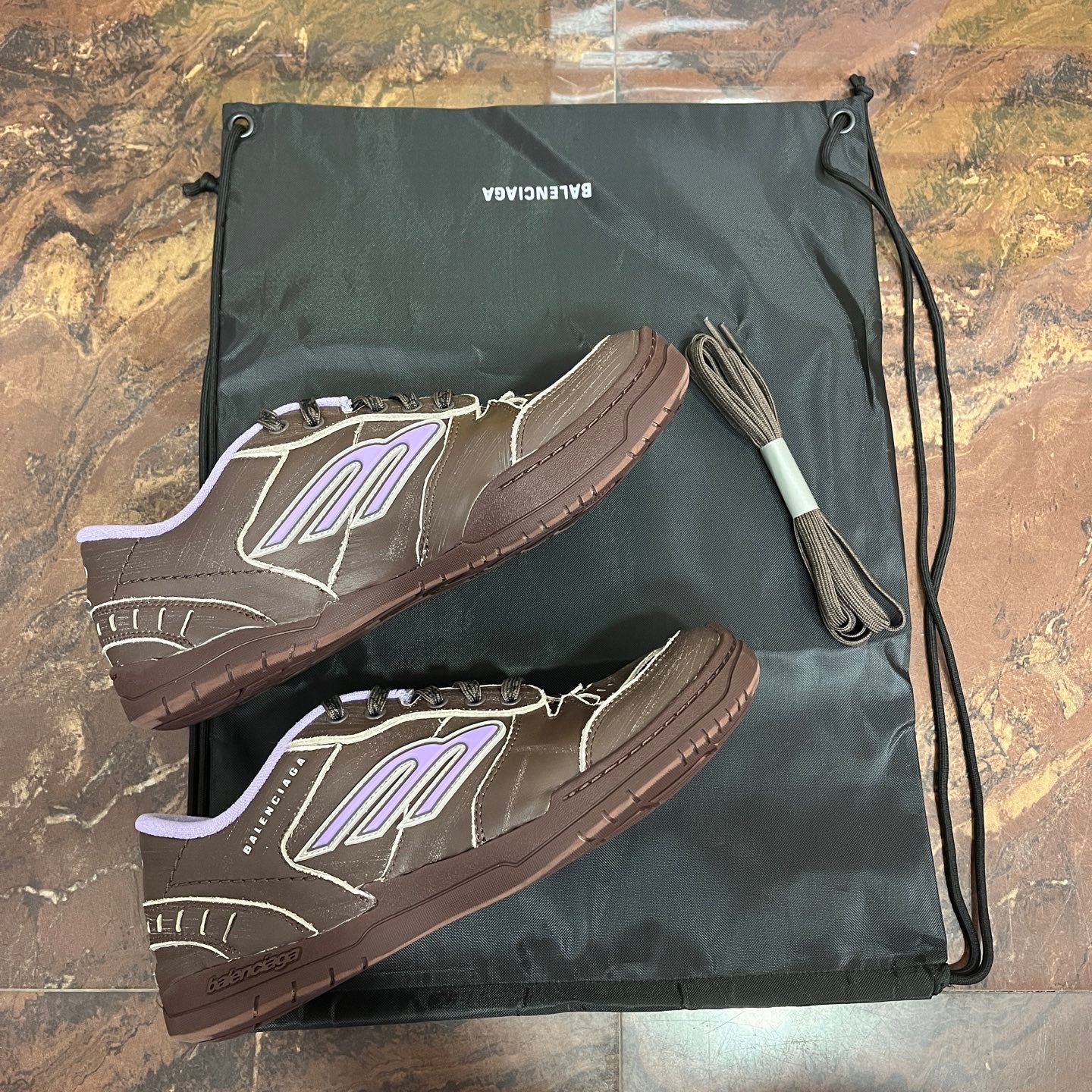 Brown Balenciaga sneakers with purple logo, textured sole, low-top design