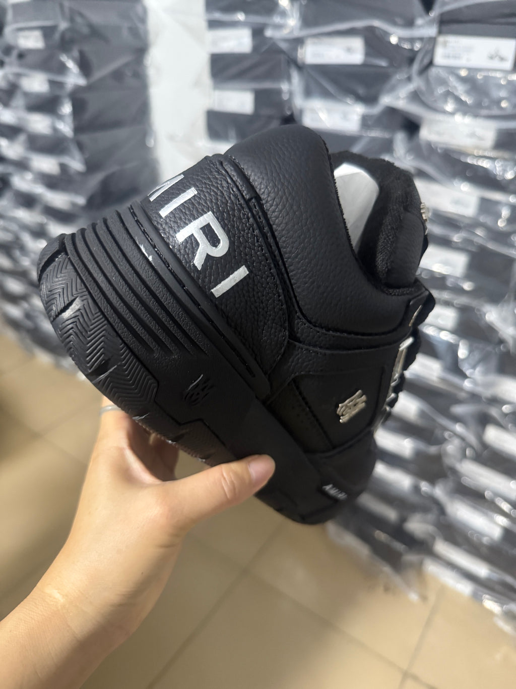 Black Amiri sneakers heel and outsole view with ribbed tread and side "AMIRI" mark