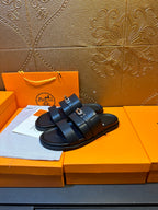 Hermes leather slide sandals featuring two dark navy straps with a gold buckle detail