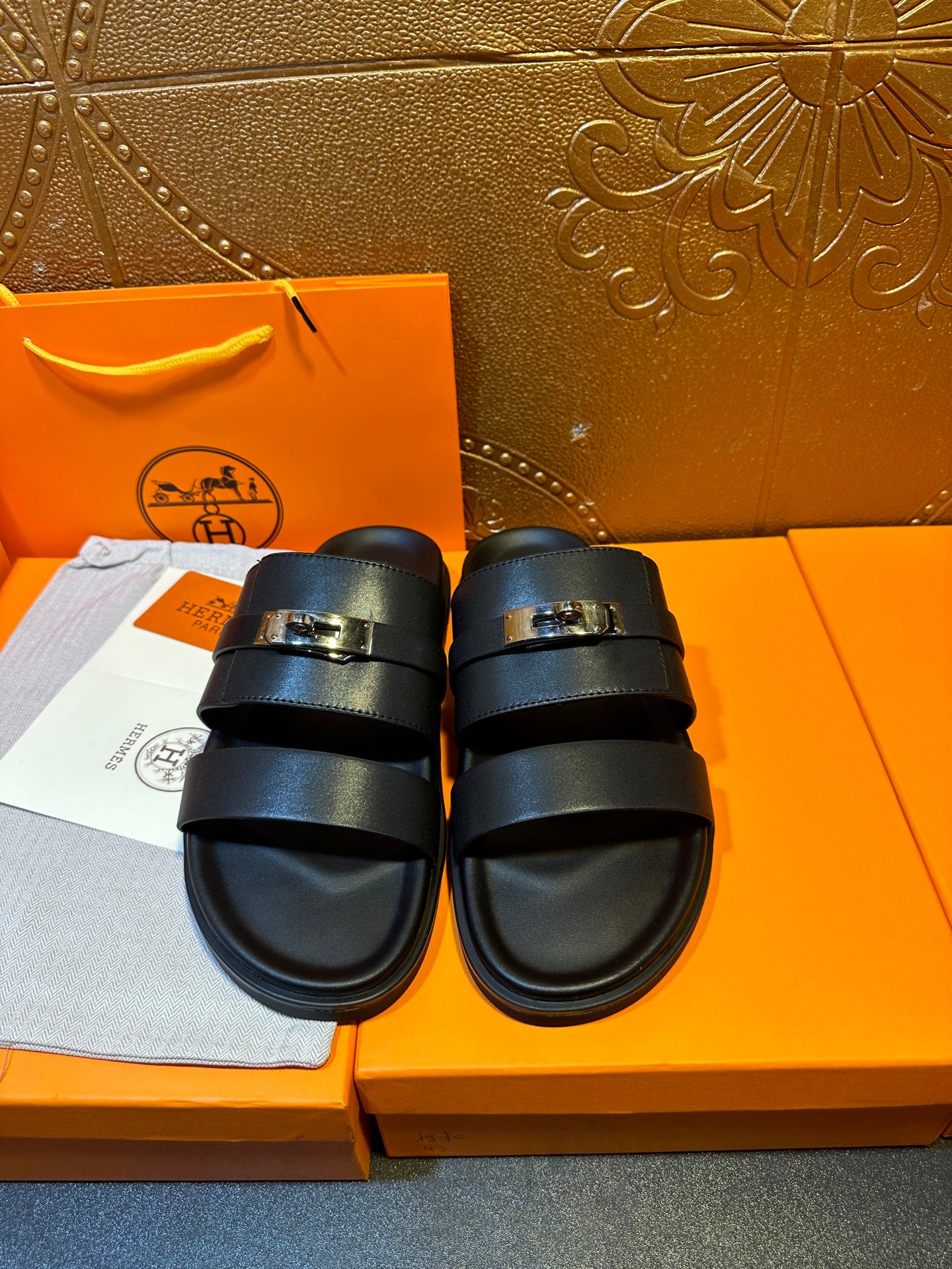 Hermes leather slide sandals with two dark navy straps and gold-tone buckle hardware