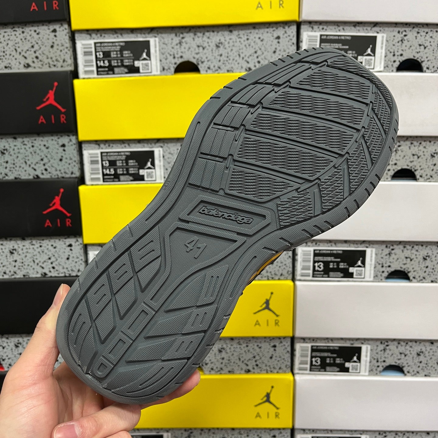 Grey rubber outsole with traction pattern and embossed logo on the heel.
