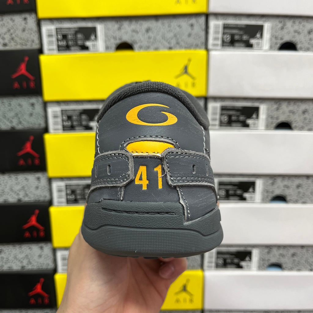 Grey sneaker heel with yellow accent mark and size label on the back.