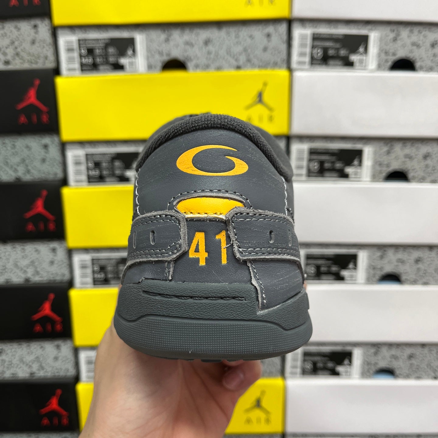 Grey sneaker heel with yellow accent mark and size label on the back.