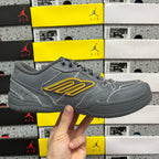 Grey lace-up sneakers with yellow logo patch on the side and cushioned collar edge.