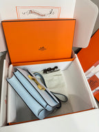 Light blue Hermes bag with long strap and gold hardware, in open box