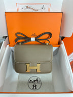 Taupe leather small crossbody bag with gold H front clasp and top handle loops
