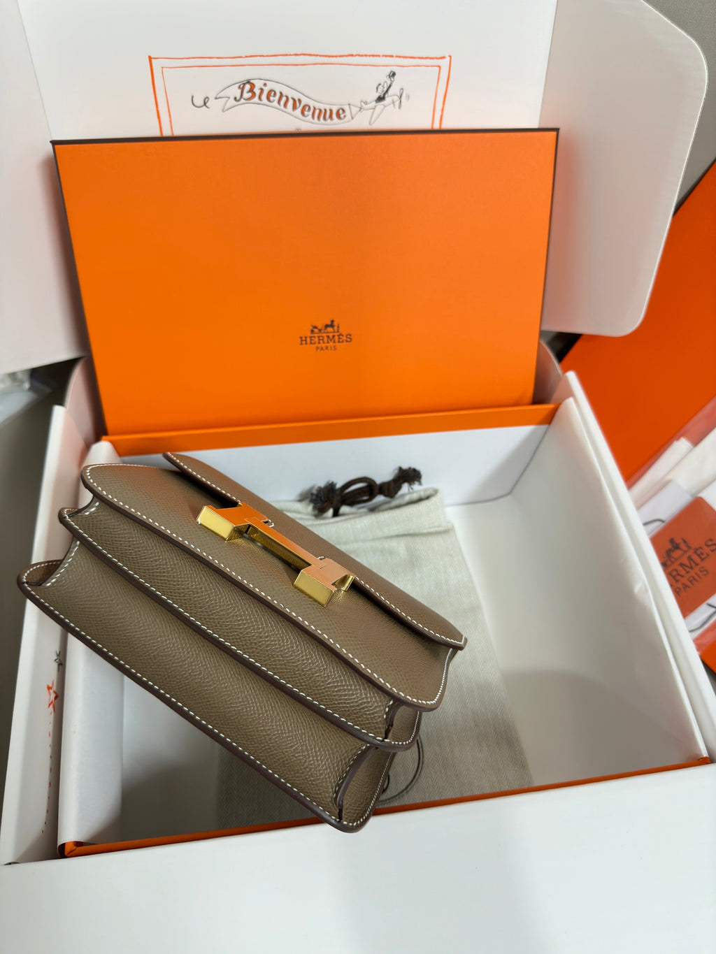 Taupe leather flap bag with gold H front clasp and attached shoulder strap