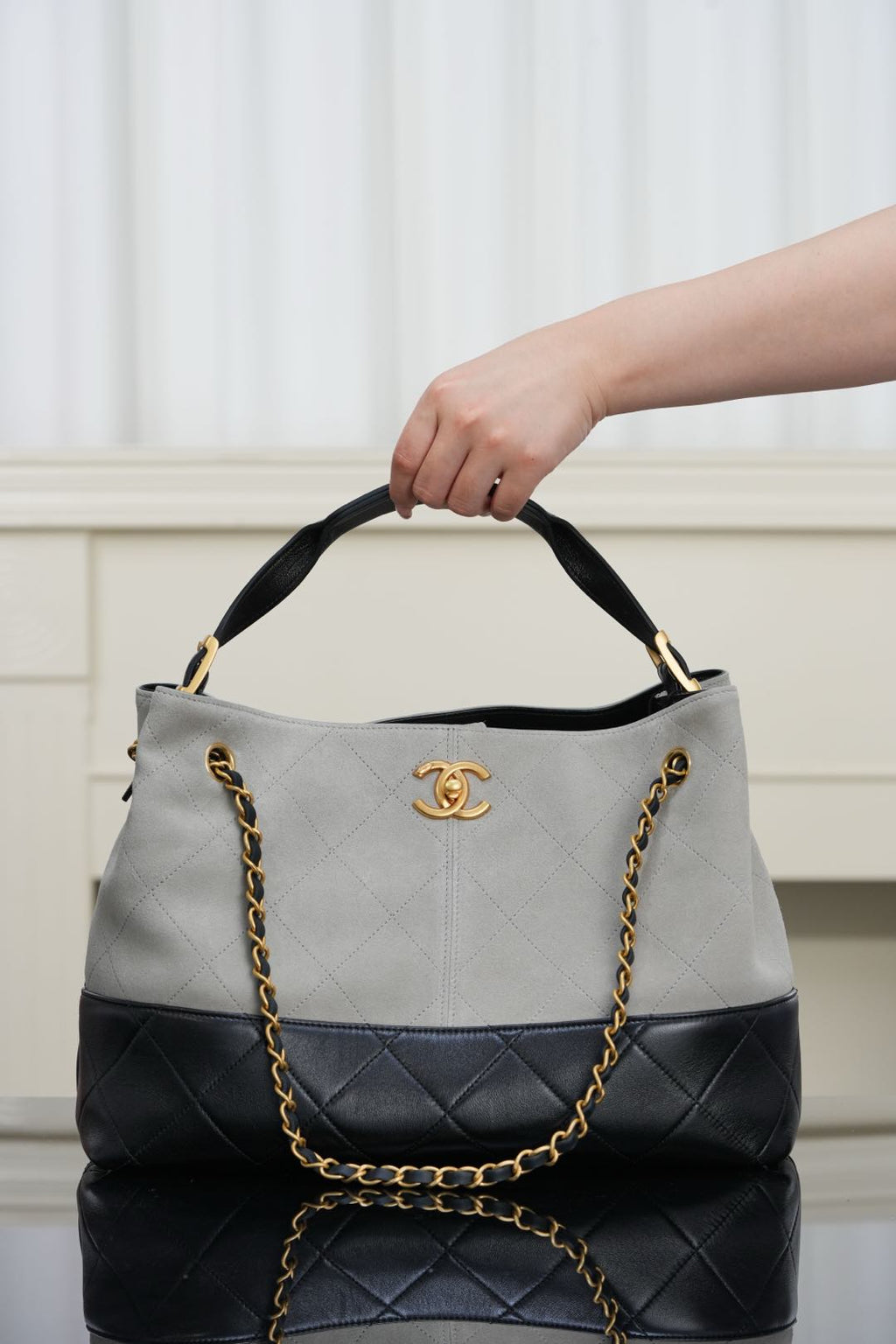 Chanel quilted handbag with top handles, light gray exterior and black lower section