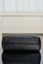 Black Chanel bag with quilted horizontal diamond pattern, no visible straps.