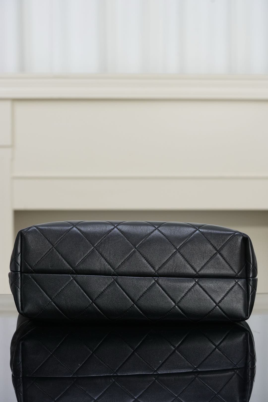 Black quilted Chanel handbag with diamond stitching and rounded top panel