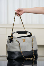 Chanel bag with quilted two-tone sides and gold chain shoulder strap, top handles.