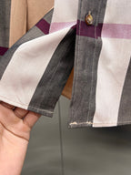 Sleeve cuff close-up on plaid long-sleeve button-up shirt with stitched trim