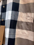Close-up of long-sleeve shirt pocket and plaid panel; gold-tone button