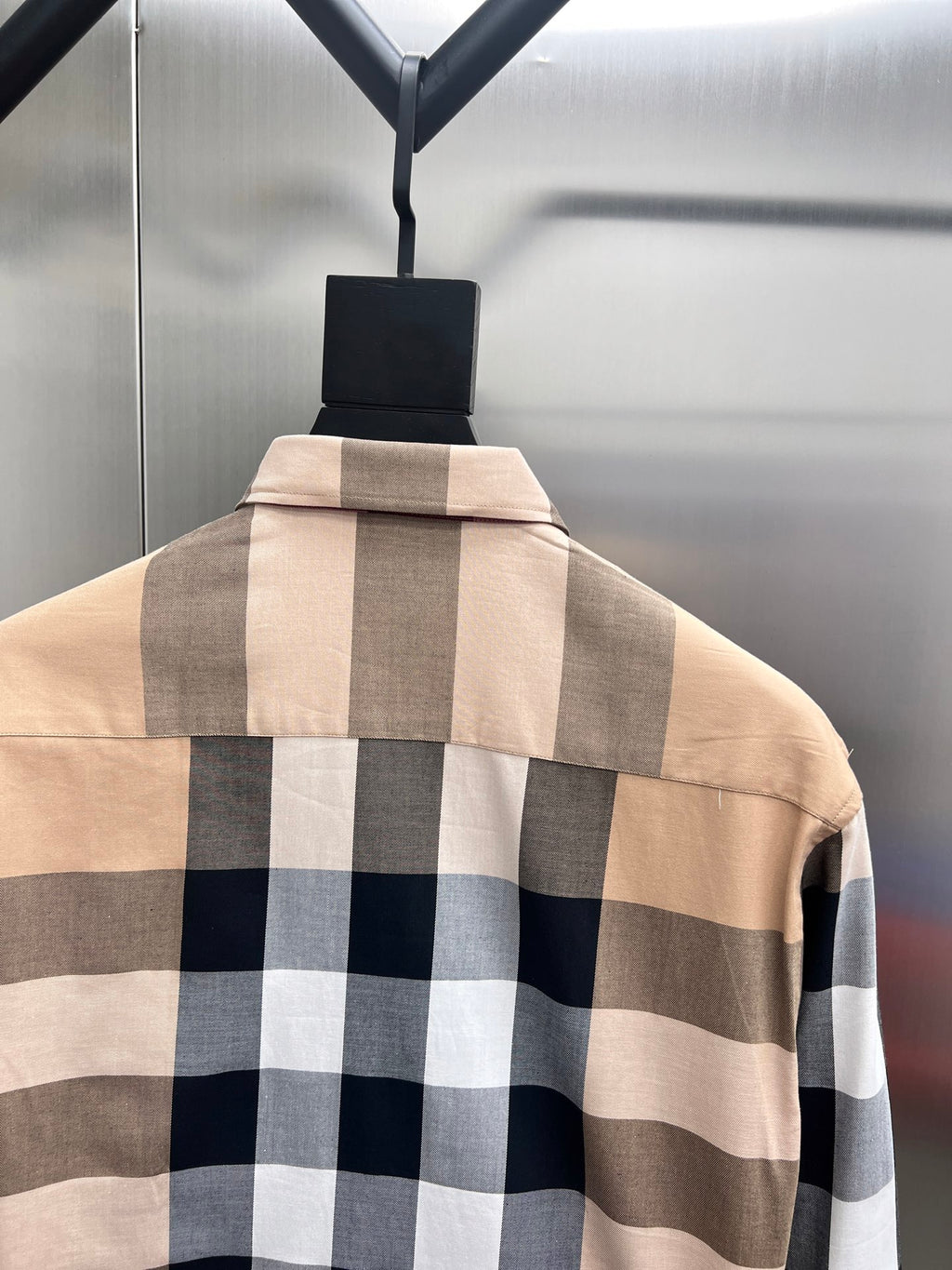 Long-sleeve shirt with beige and dark plaid pattern on back yoke