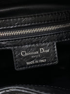 Dior black leather bag tag reading Christian Dior Paris and Made in Italy