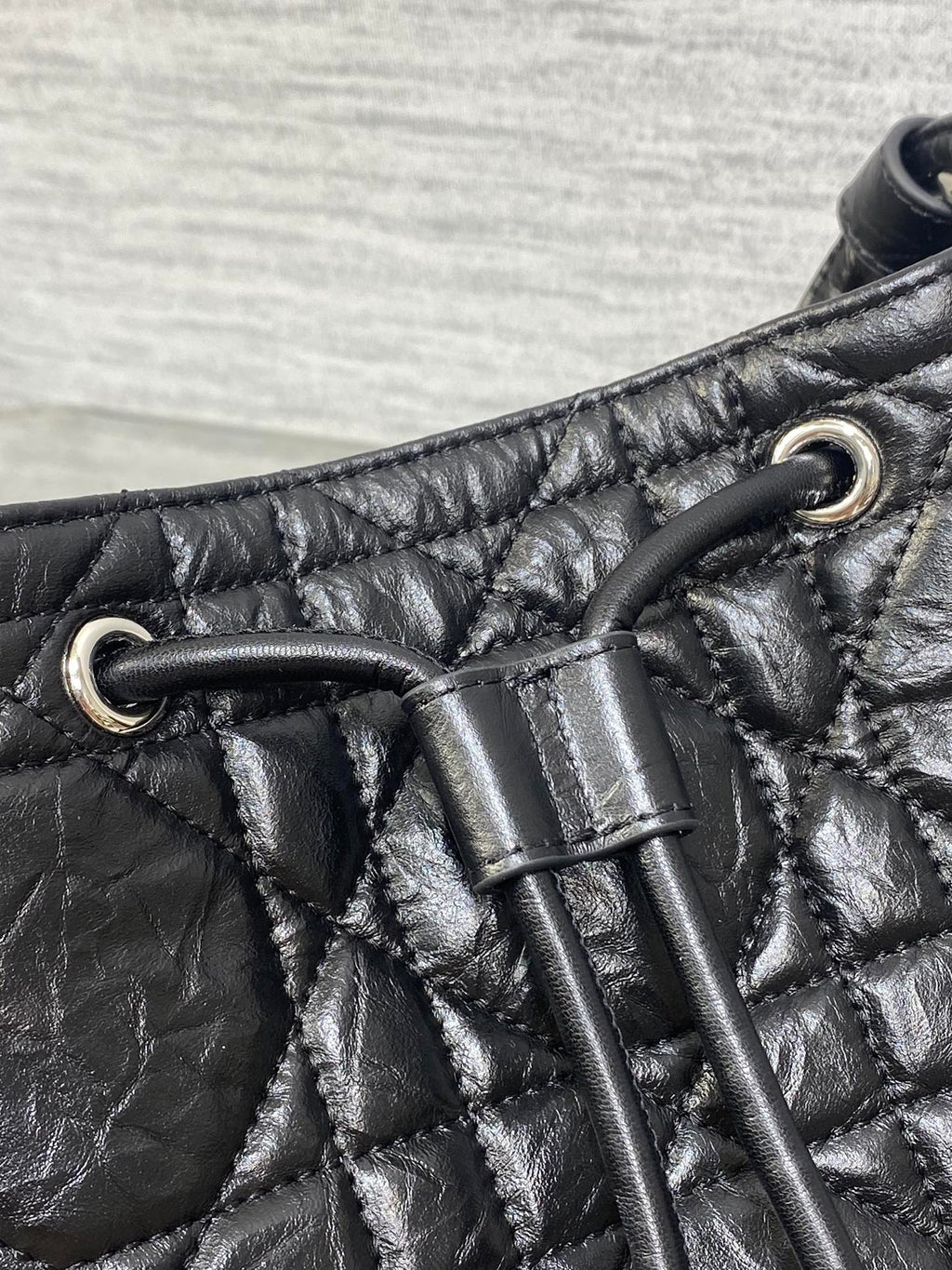 Dior black leather strap detail with metal grommets and stitched quilting