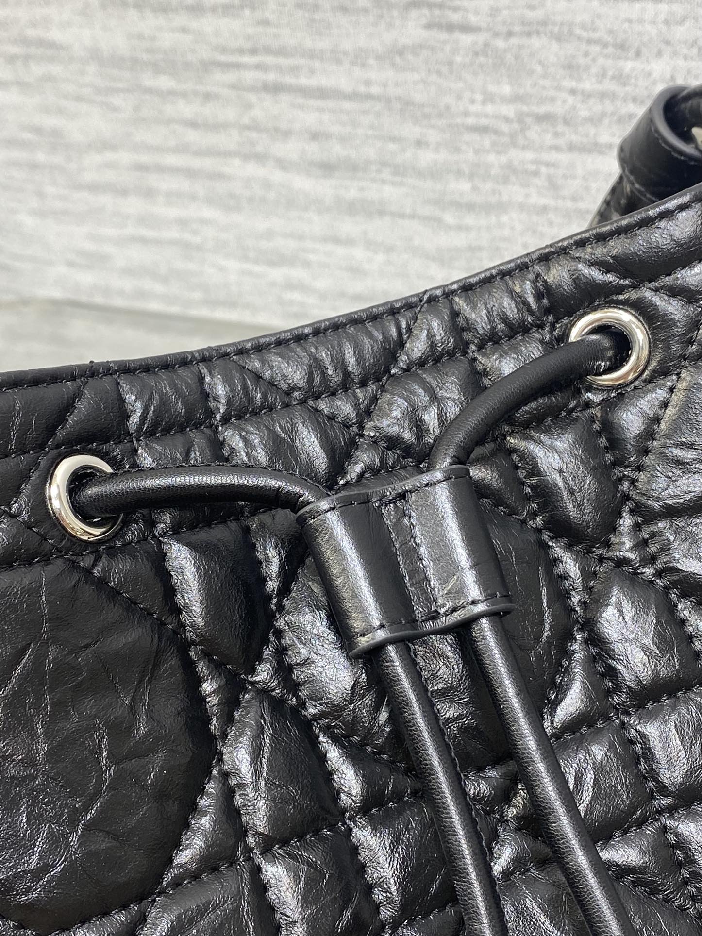 Dior black leather strap detail with metal grommets and stitched quilting