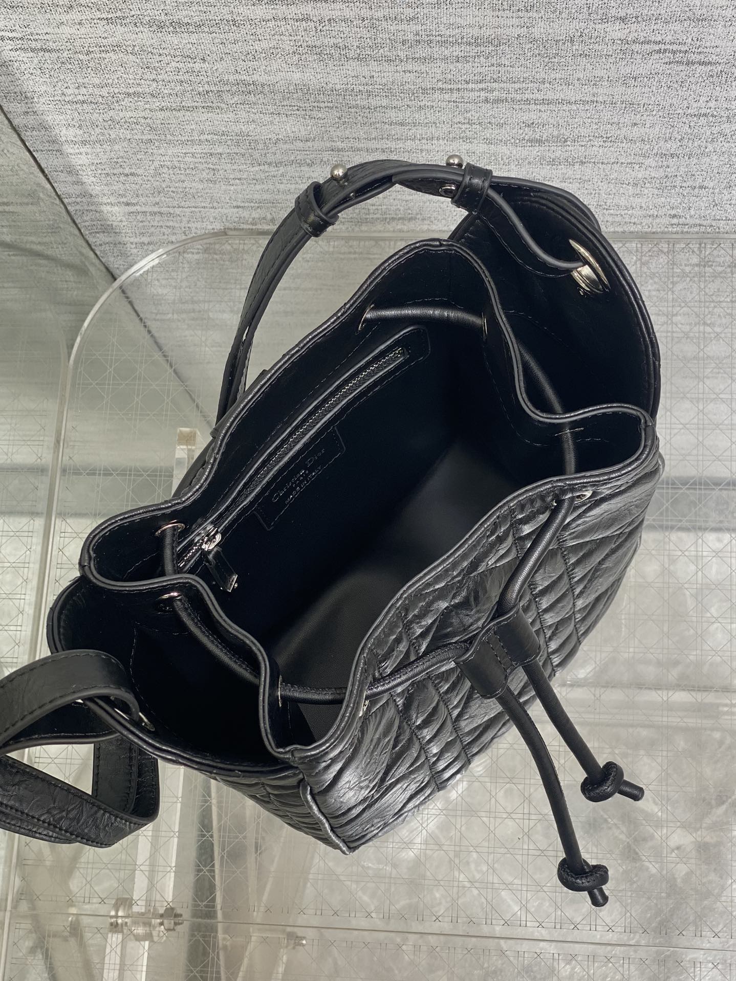 Dior black quilted leather bag open, showing interior and drawstring tie