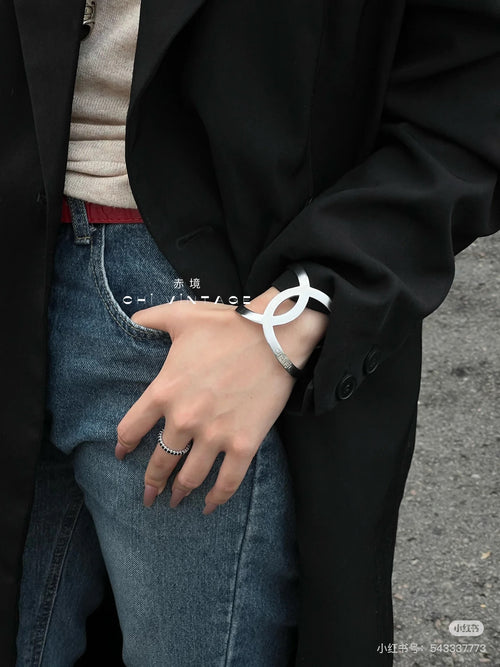 Silver-tone Chanel CC bracelet on wrist with ring and cuff