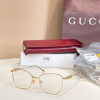 Gucci eyeglass frames with light gold metal rims, clear oval lenses, and logo temples.