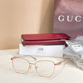 Gucci eyeglass frames with light gold metal rims and clear oval lenses.