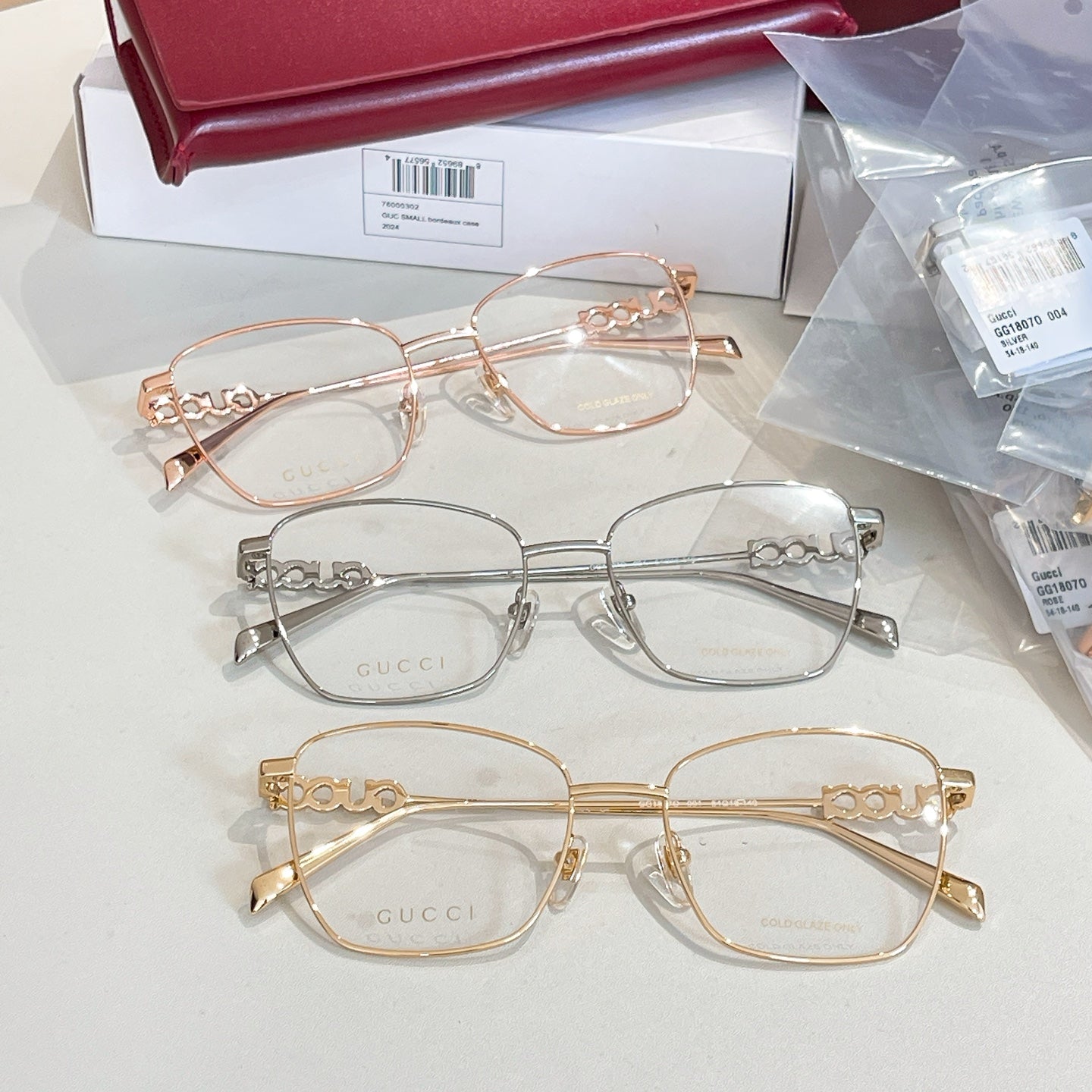 Gucci eyeglass frames set with rose-gold, silver, and gold-tone oval frames.
