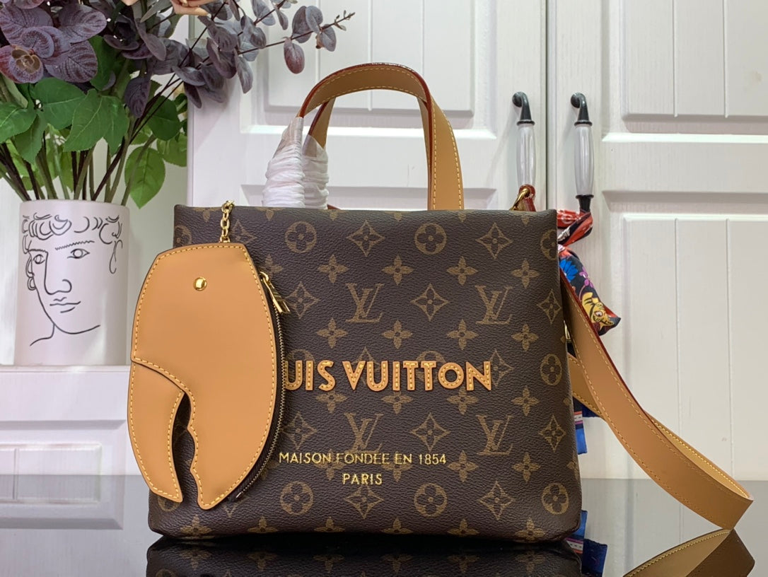 Monogram tote bag with tan leather trim, top handles, and front oval patch pocket