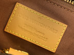 Tan leather bag label with Louis Vuitton engraving and contrast yellow stitching