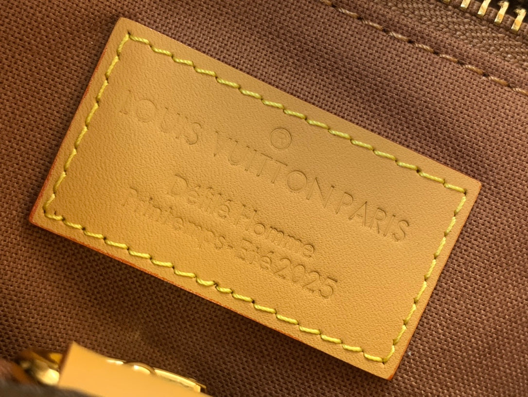 Tan leather bag label with Louis Vuitton engraving and contrast yellow stitching