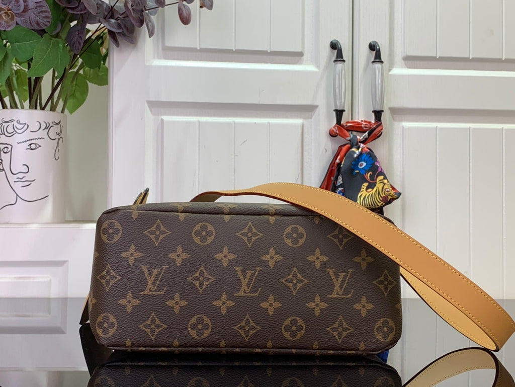 Monogram shoulder bag with tan leather strap and top handle, front corner view