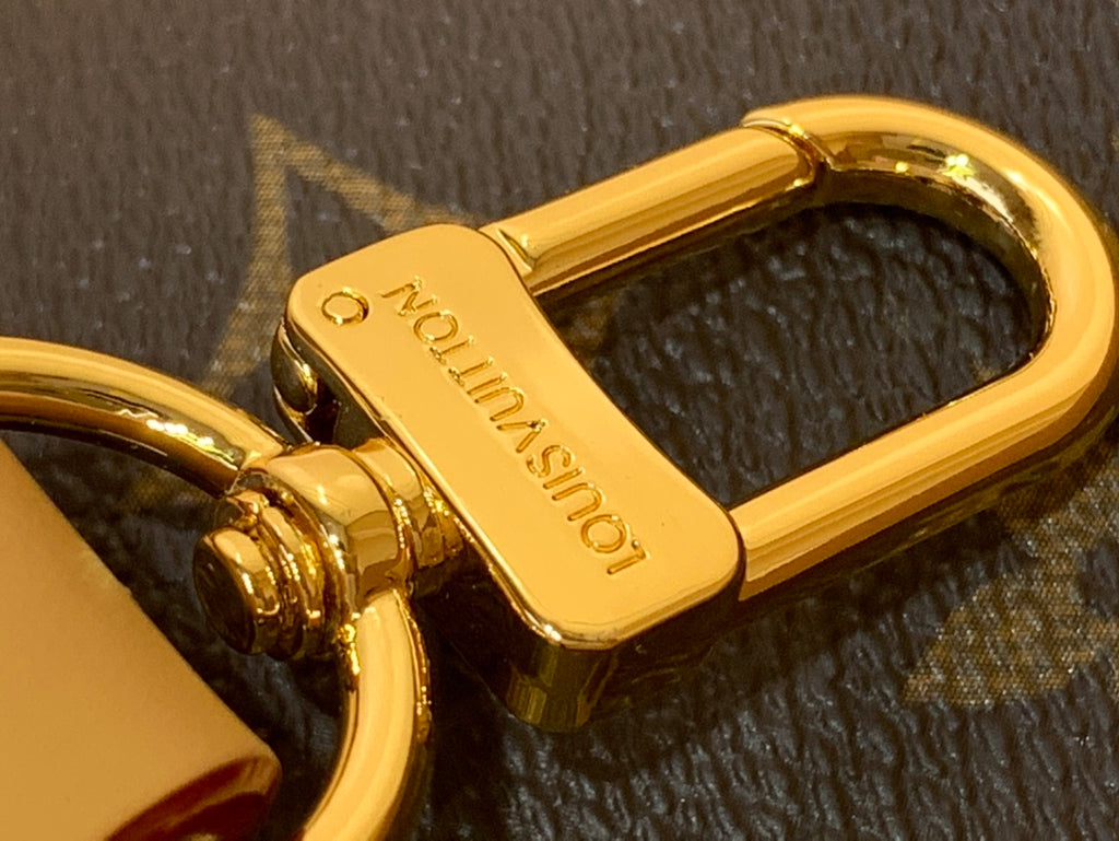 Gold-tone turn-lock clasp with Louis Vuitton engraving on monogram canvas