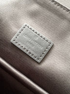 Men's Louis Vuitton bag close-up of interior brand label on dark fabric lining.