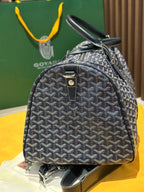 Goyard duffel bag with navy patterned canvas, short top handle, and front lock detail