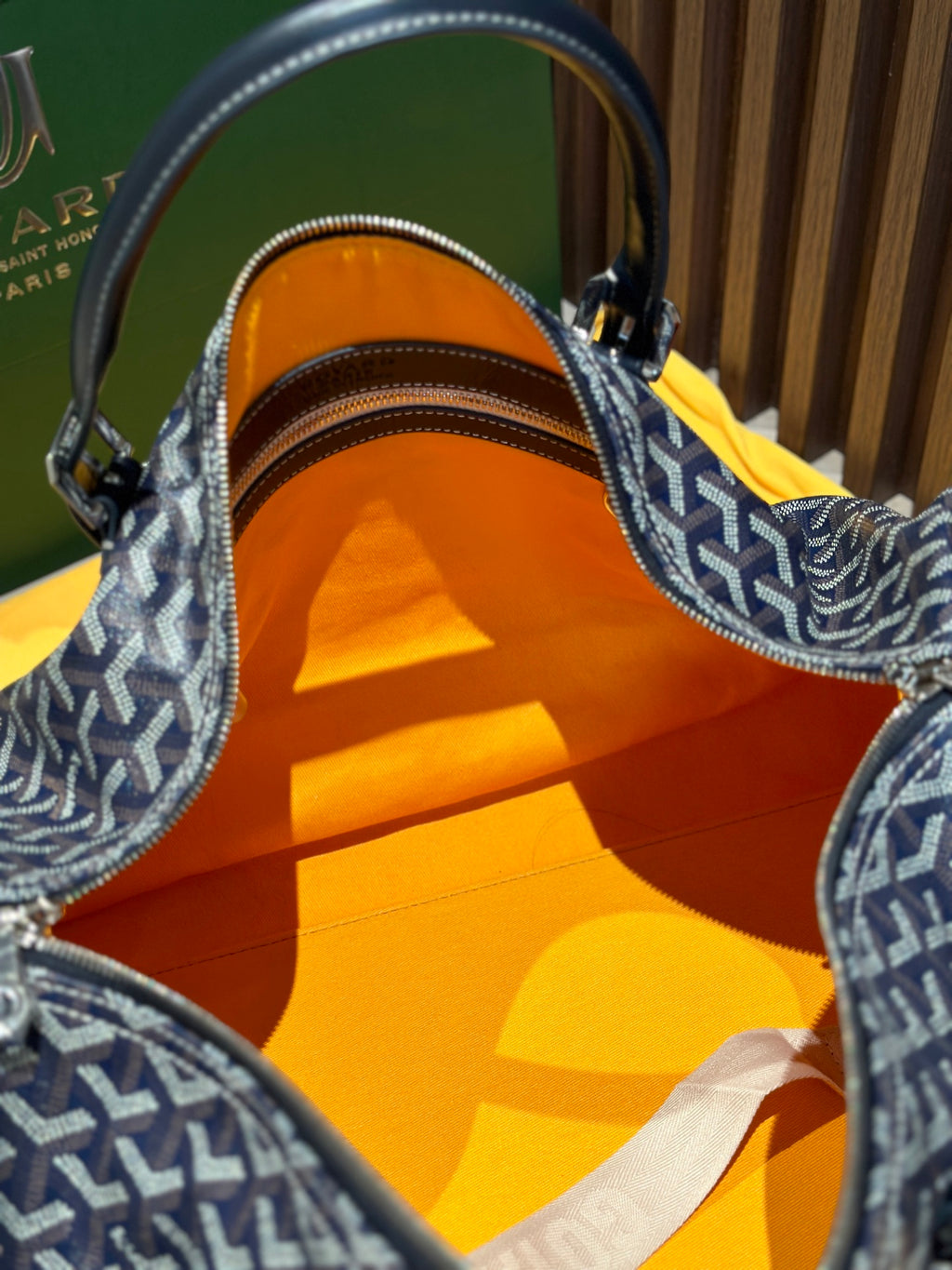 Goyard duffel bag open top showing orange fabric lining and zipper track