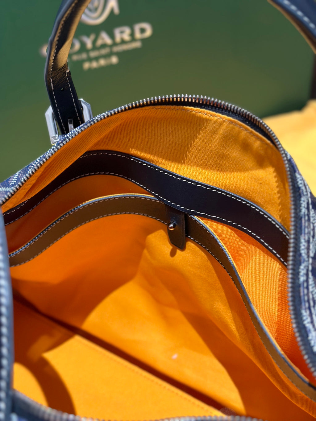 Goyard duffel bag interior close-up with orange lining and stitched trim