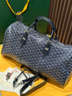 Goyard duffel bag angled view with navy patterned canvas, handles, and front strap pockets