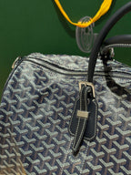 Goyard duffel bag close-up with textured navy patterned canvas and small front strap details