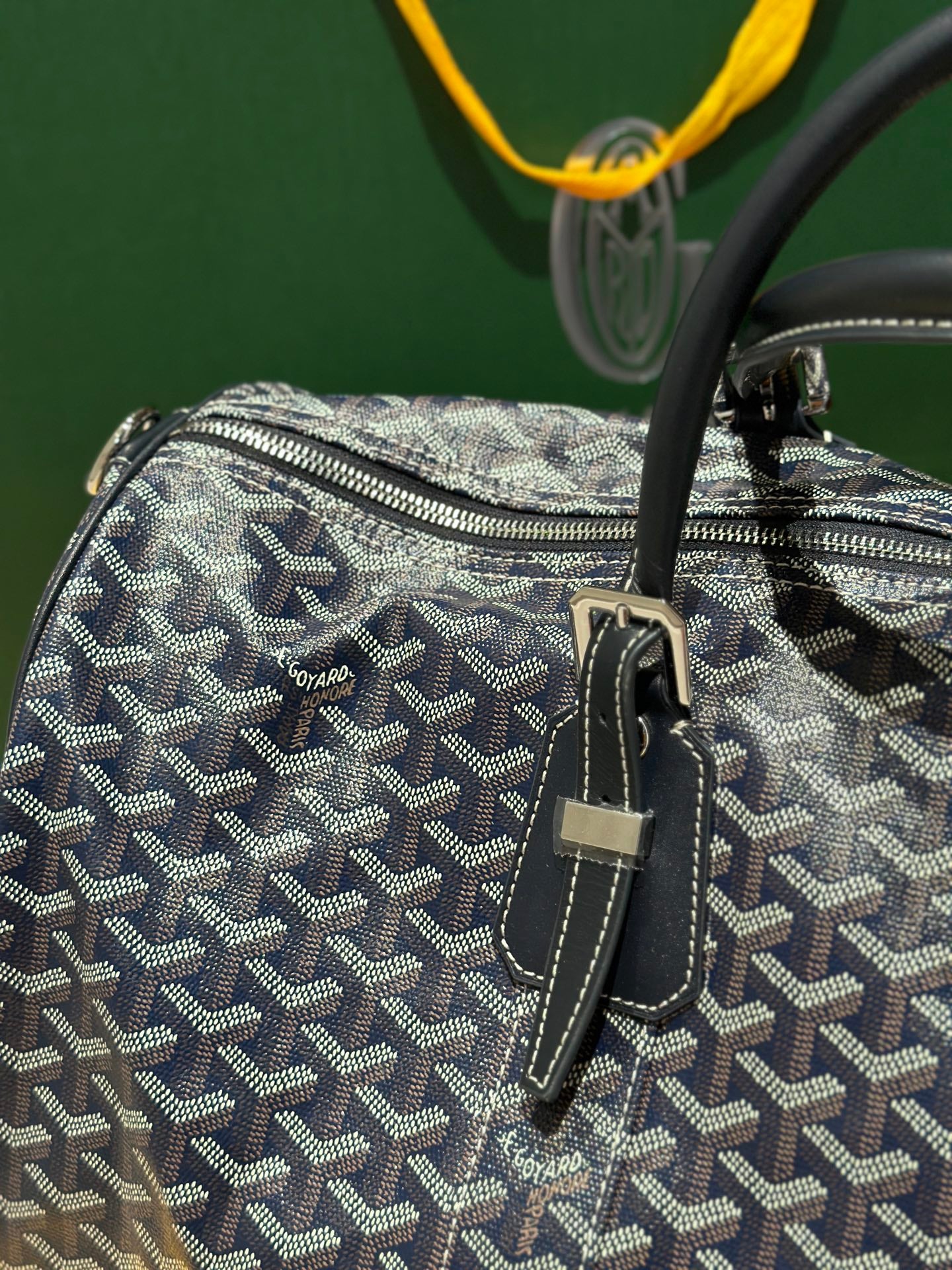 Goyard duffel bag close-up with textured navy patterned canvas and small front strap details