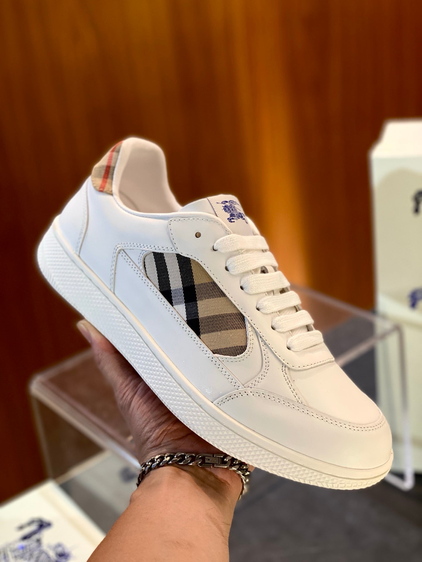 White sneaker with tan and dark check side panel, lace-up closure and blue logo