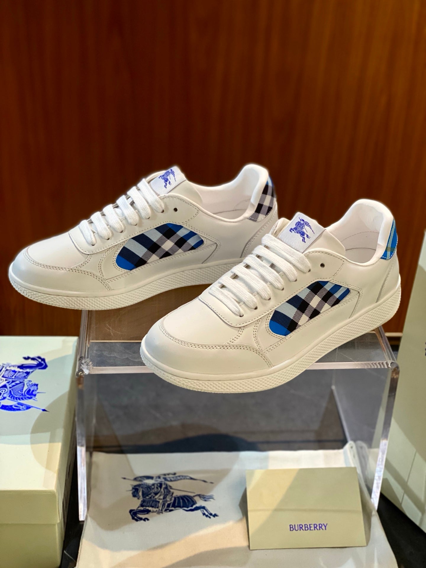 White leather low-top sneakers with blue check side panel and lace-up closure