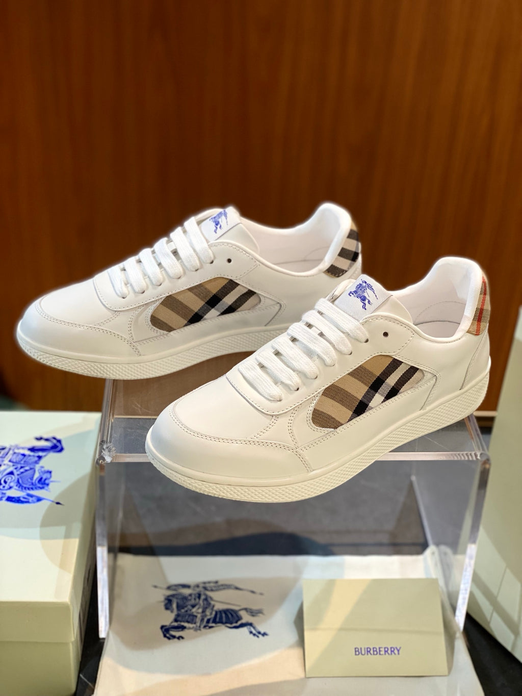 White sneakers with tan and blue check side panels and lace-up front