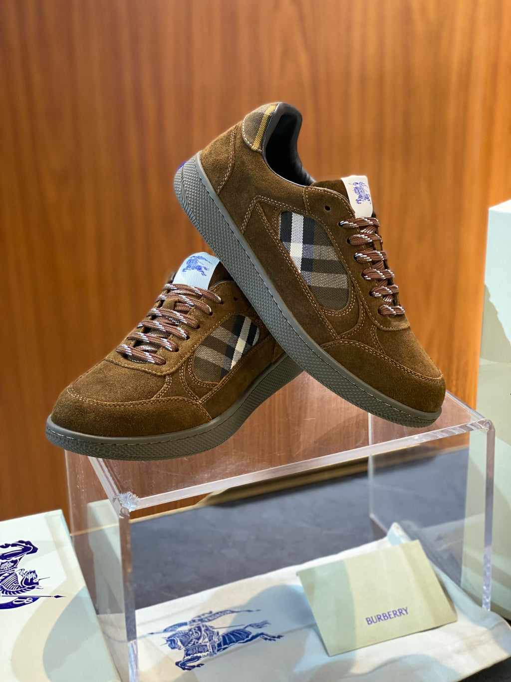 Pair of brown suede low-top sneakers with check panel accents and lace-up detail