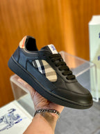 Dark green low-top sneaker with plaid side panel and lace-up, orange trim at collar