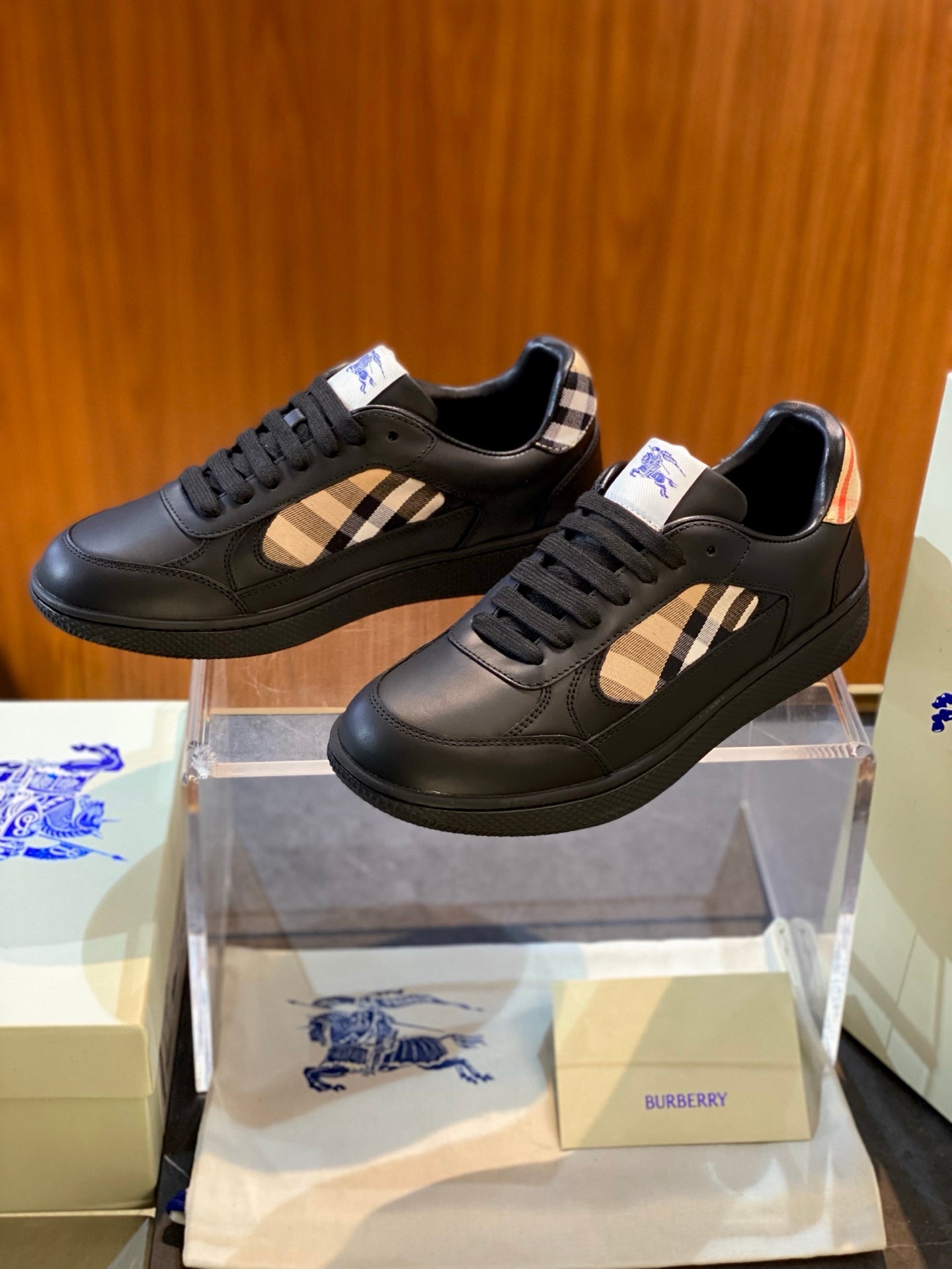 Black leather low-top sneaker with Burberry plaid side panel and blue horse logo