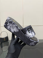 Fendi single slide sandal close-up, dark floral strap with FF logo detail.