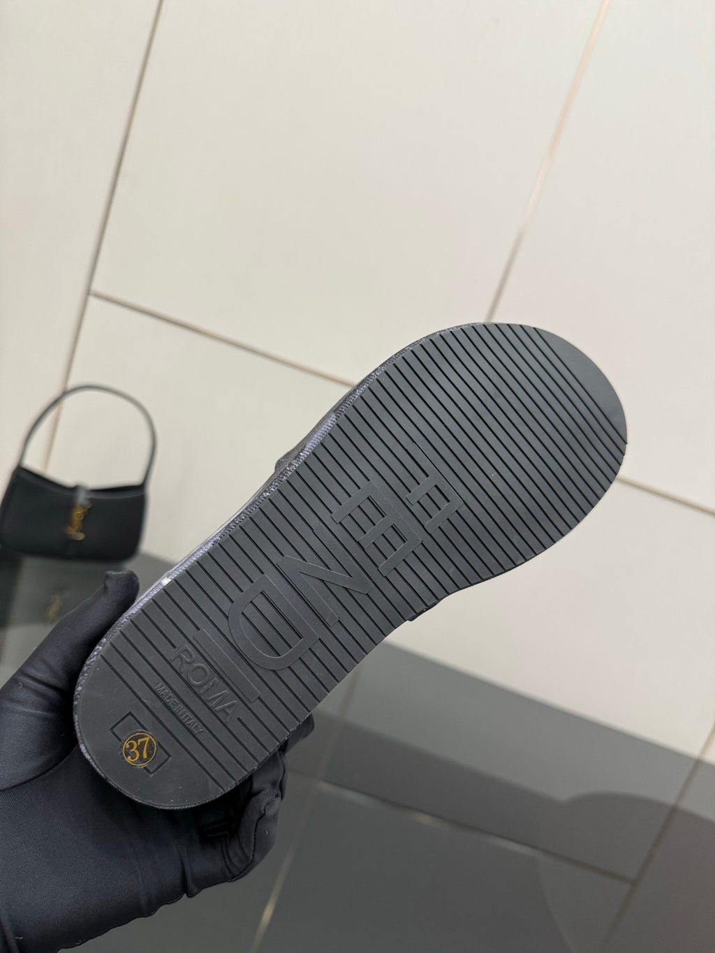 Fendi slide sandal outsole, textured rubber tread with small logo marking.