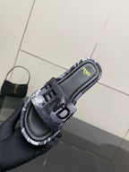 Fendi slide sandal close-up, black footbed with 'FENDI' logo on the strap.