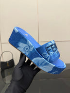Fendi women's blue slide sandal, close-up of FF logo strap and patterned upper.