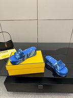 Fendi women's blue slide sandals, pair view on yellow shoebox.